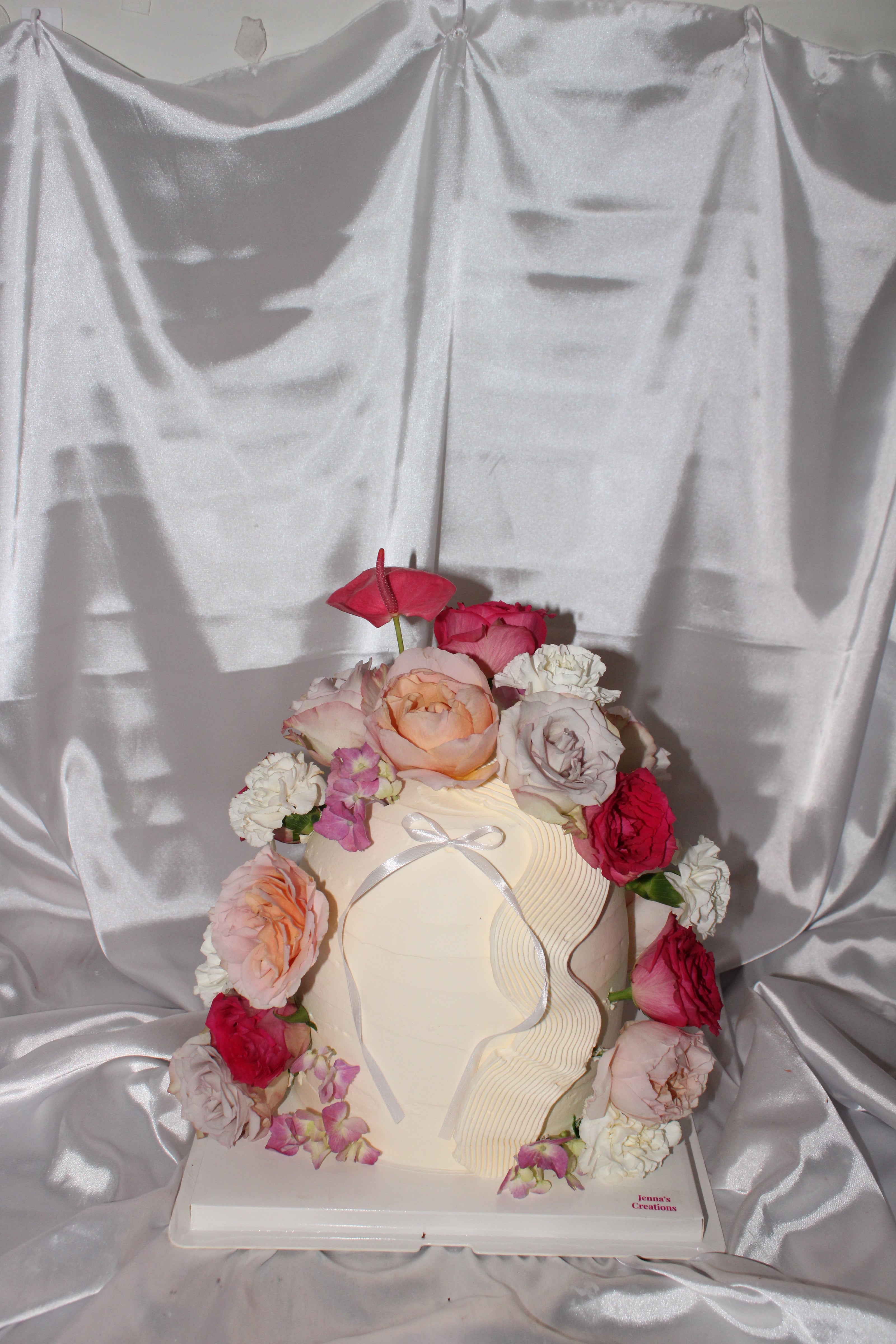 Decorative item with flowers and a light bulb on a white draped background