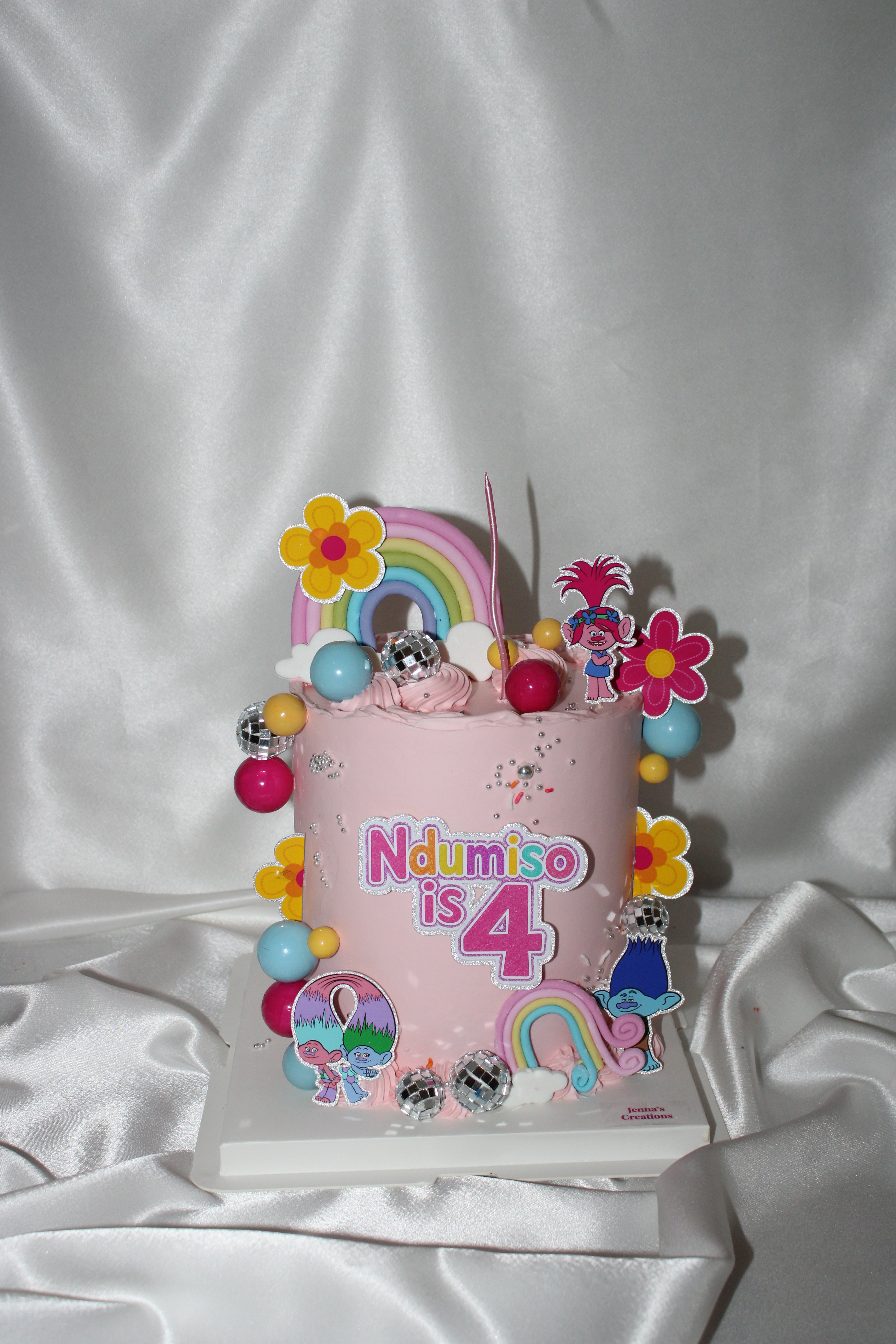 Children's birthday cake with colorful decorations on a white background