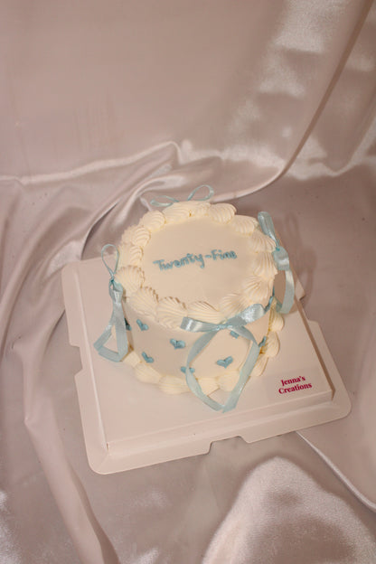 Small round cake with decorative elements on a plain background