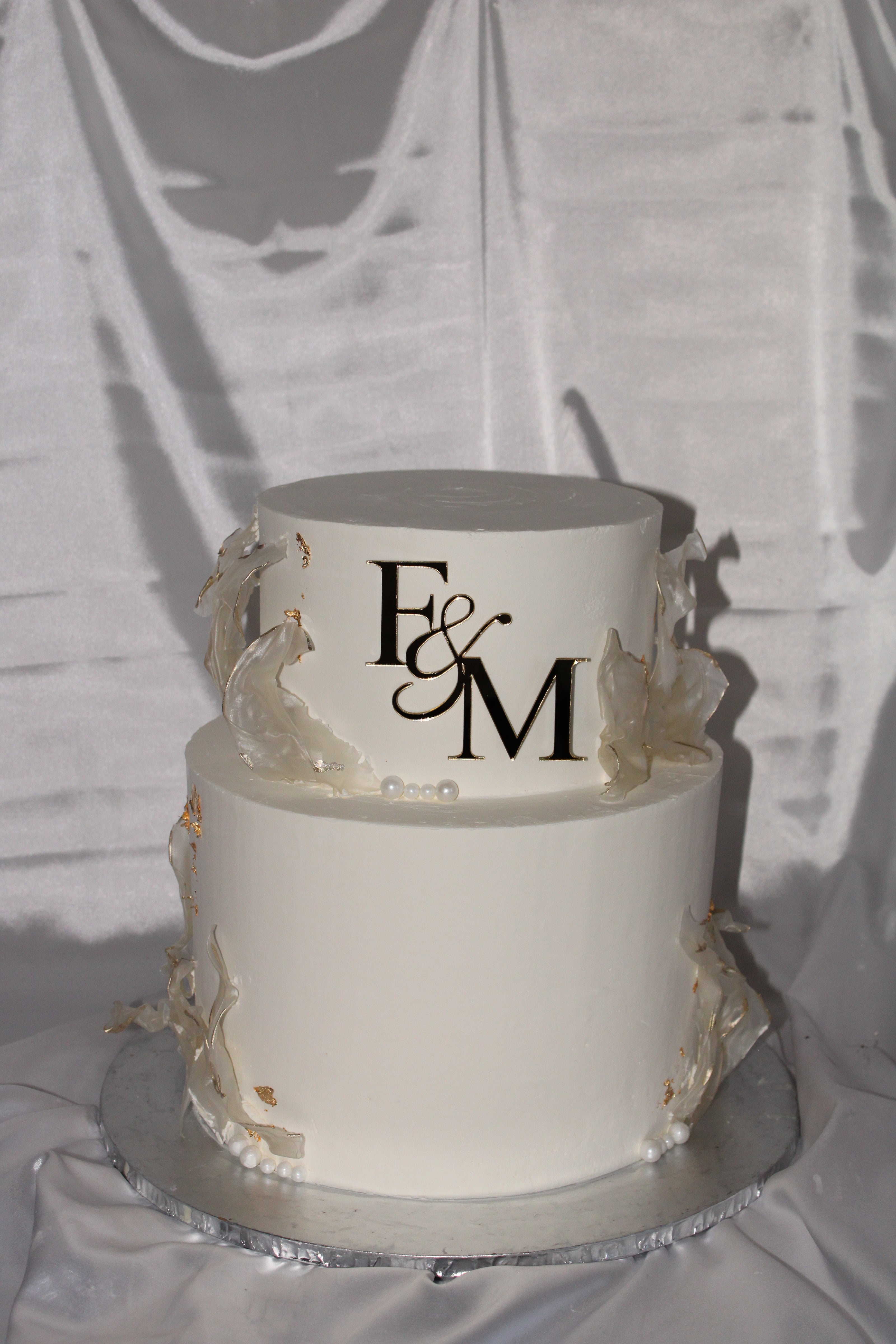 Decorative cake with 'F&M' initials on a white background