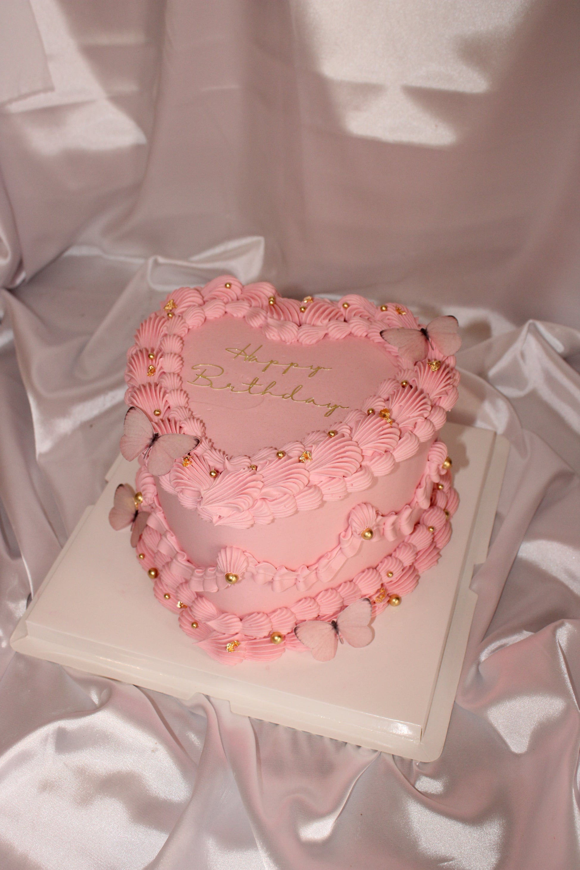 Pink hoop earrings with gold accents on a pink satin background
