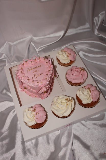 Pink and white cupcakes in a box on a light fabric background