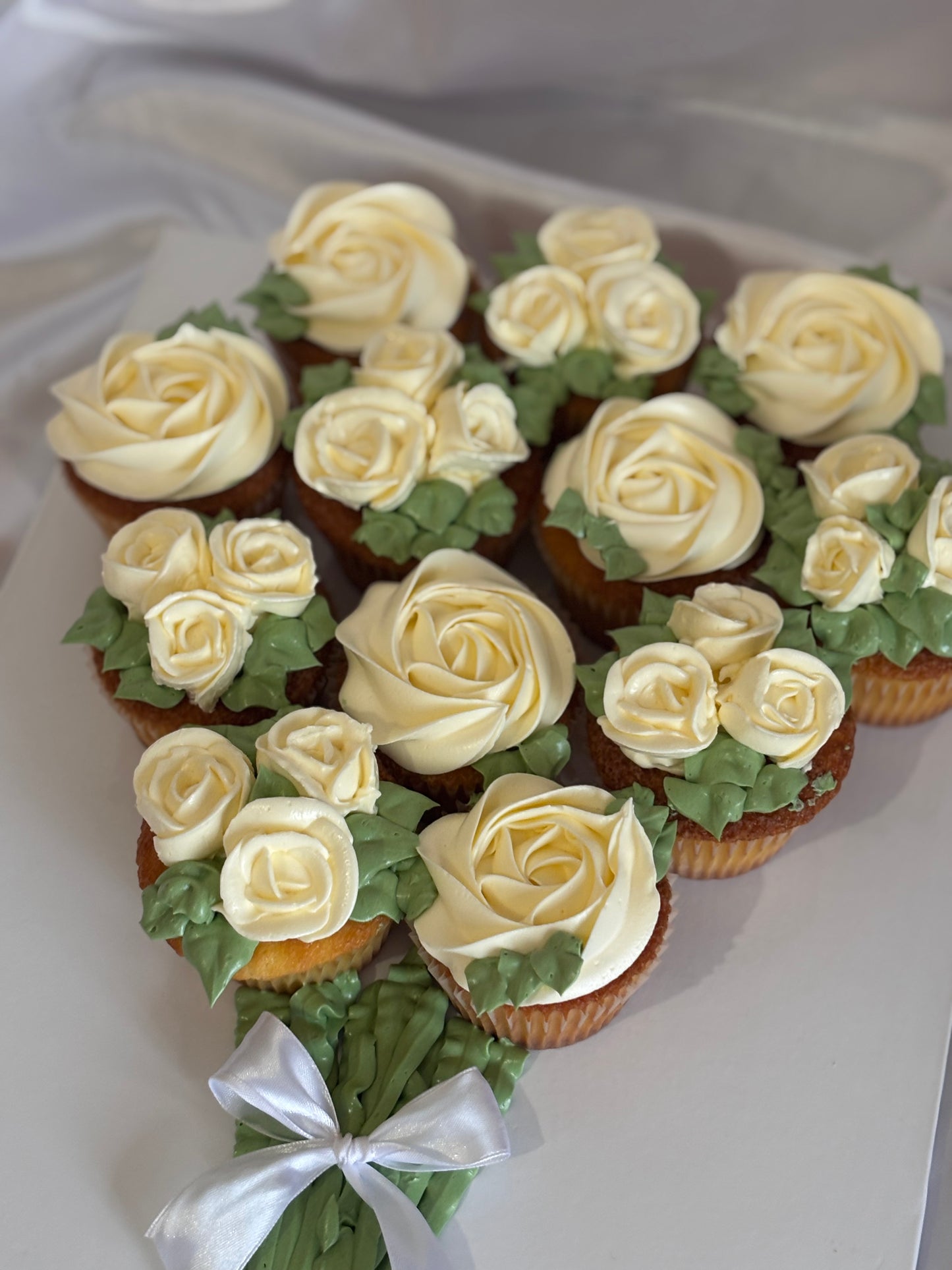 Hand-piped ivory buttercream rose cupcakes in a bouquet arrangement