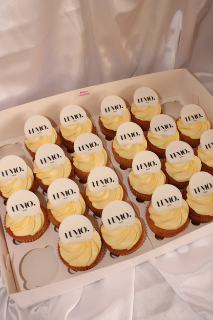 Close-up of frosted cupcakes featuring custom printed company logos on edible toppers.