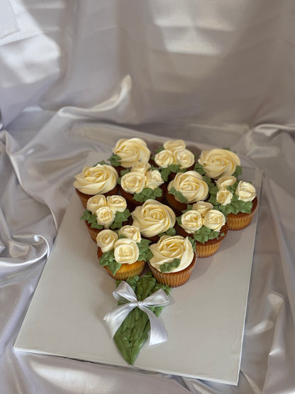 Floral cupcake bouquet featuring white buttercream roses with a satin bow