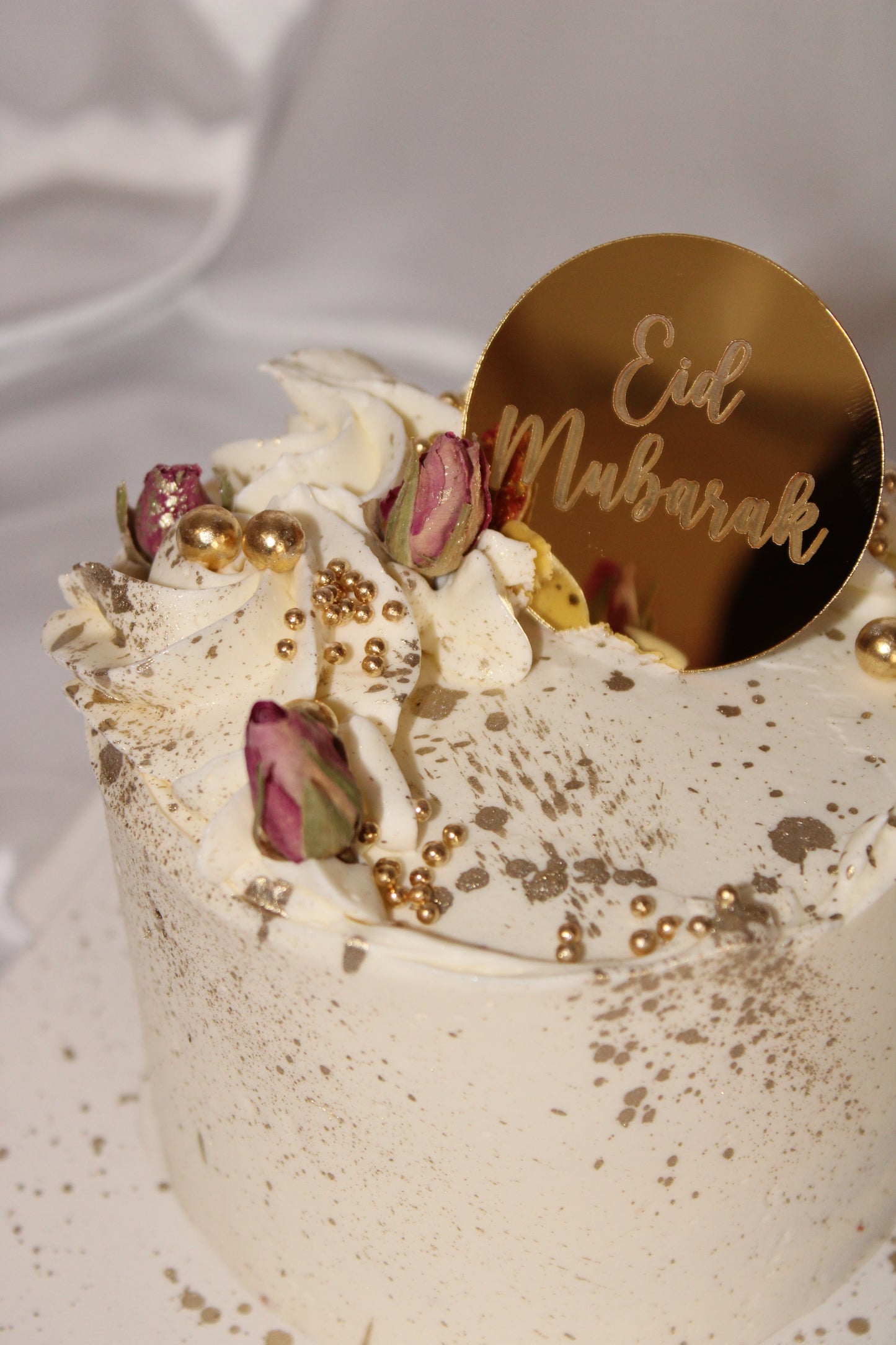 Modern Eid celebration cake with gold details and floral accents
