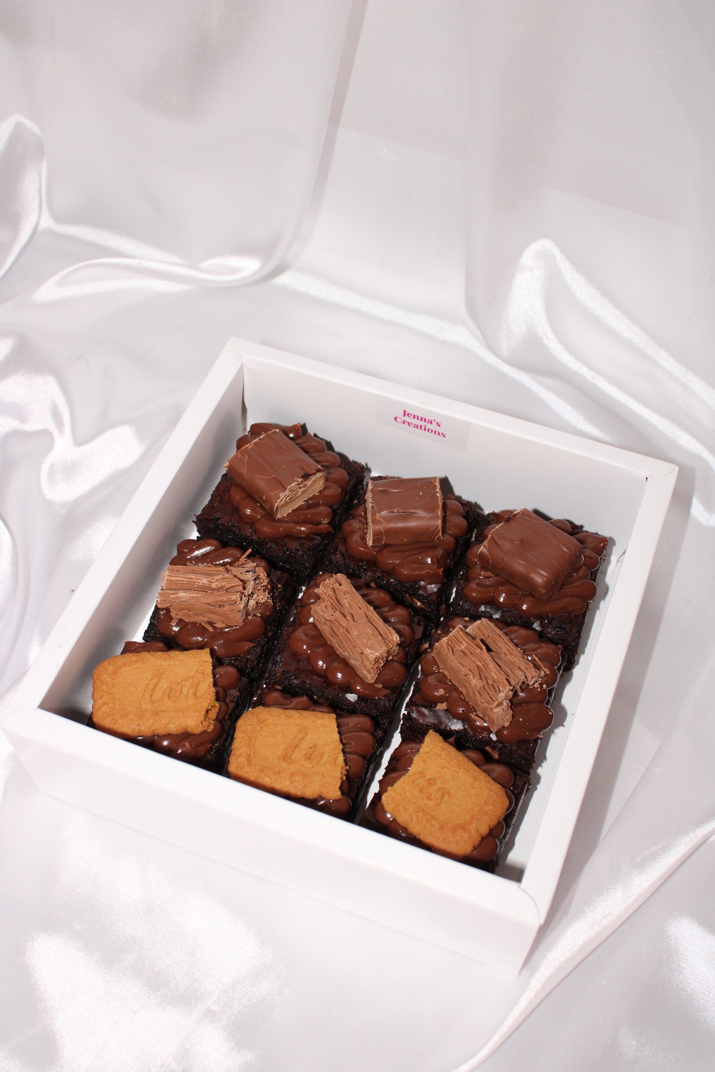 Selection of indulgent brownies featuring assorted toppings like milk chocolate pieces and biscuit layers