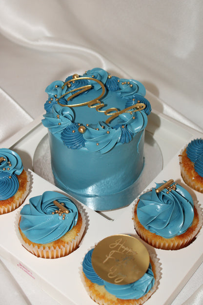 Mini blue celebration cake surrounded by six coordinating cupcakes in a premium Father’s Day gift box.