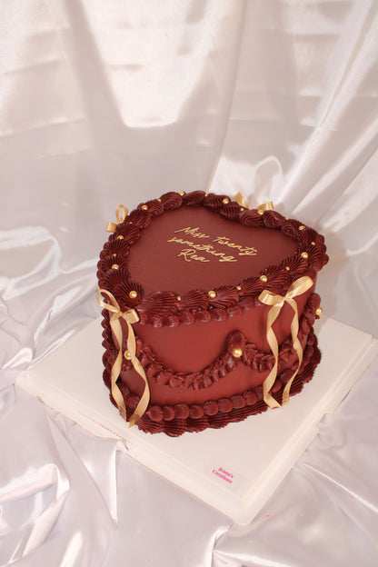 Heart-shaped chocolate gift with gold accents on a white background